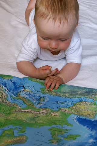 toddler studying a world atlas